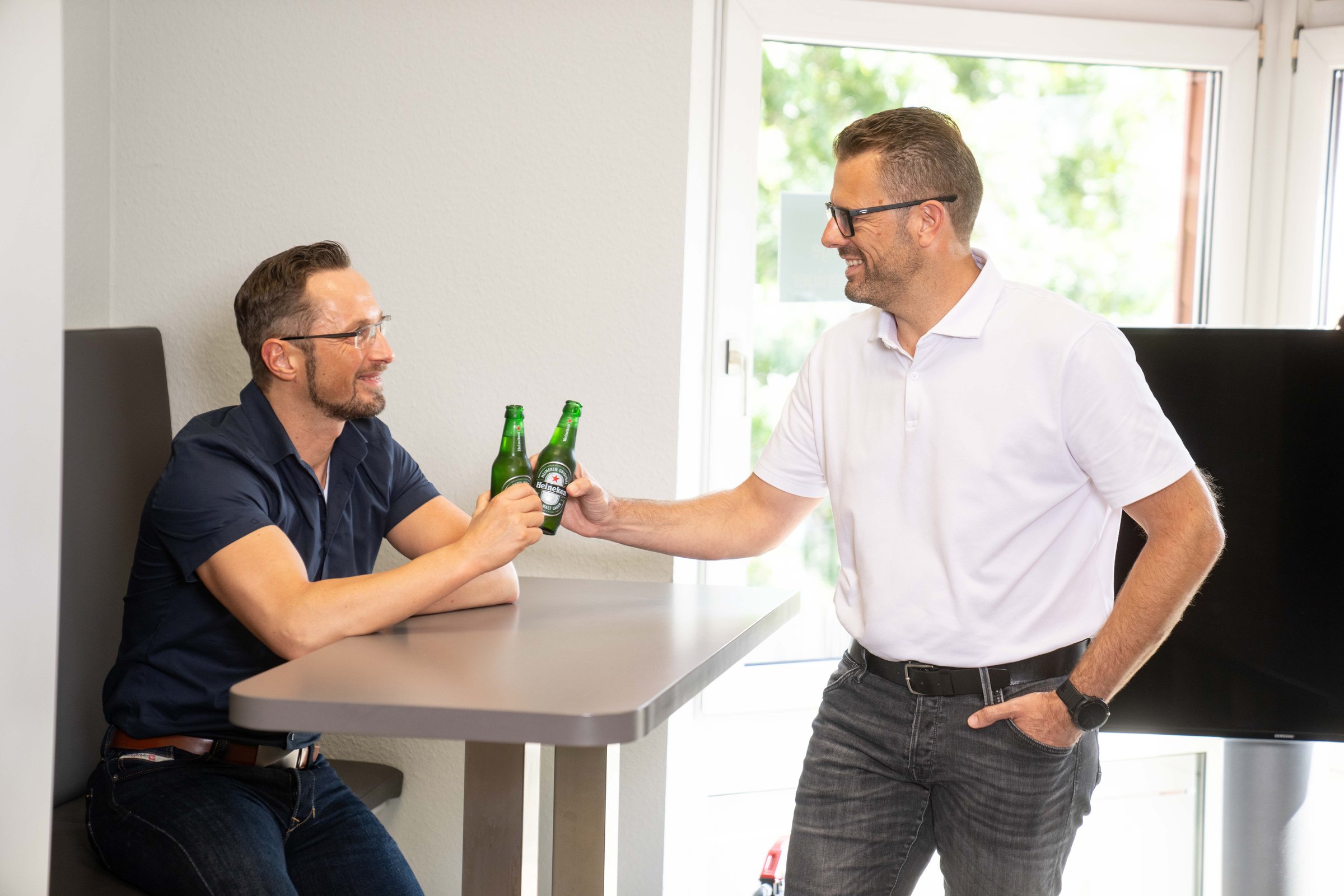 Die Geschaeftsfuehrer Stefan Schumacher und Florian Janssen stossen mit einem Bier an.